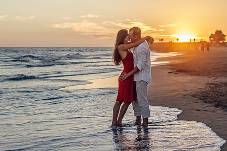 man and woman standing on seashore during daytime thumbnail