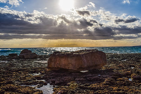 brown rock near body of water thumbnail