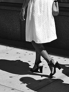 grayscale photo of person walking on gray floor thumbnail