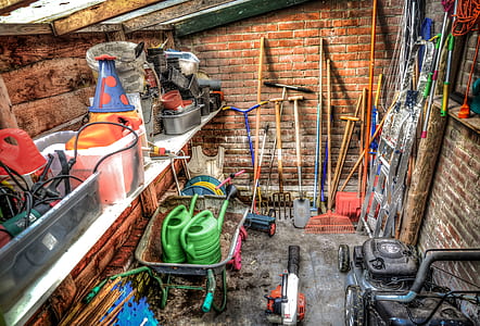 two green watering cans on wheelbarrow thumbnail