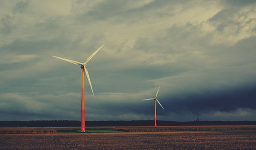 two pink-and-white wind turbine under cloudy sky thumbnail