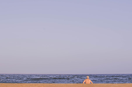 man sitting in front of ocean thumbnail
