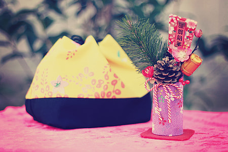 pink cylindrical case with pine cone beside yellow and black bag thumbnail