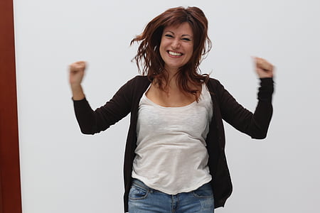 woman wearing white tank top and black sweater near white wall thumbnail