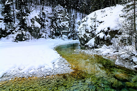 snow covered field beside body of water thumbnail