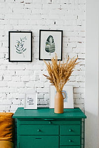 wheat grain in beige metal container on green wooden cabinet with drawer beside white wall paint thumbnail