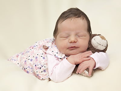 close shot of baby holding plush toy thumbnail