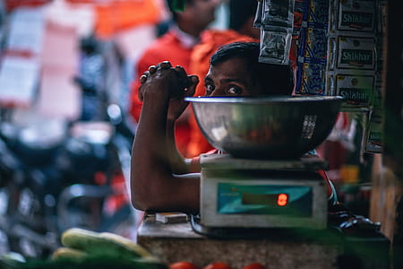 man sitting beside digital scale on selective focus photo thumbnail