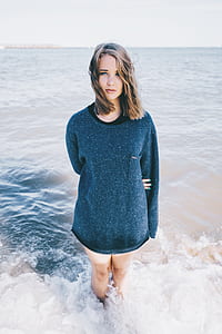 woman in black long-sleeved shirt standing on body of water thumbnail