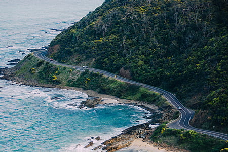 gray asphalt road near on body of water thumbnail