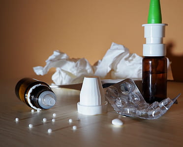 two brown labeled plastic bottles and empty blister pack on table thumbnail