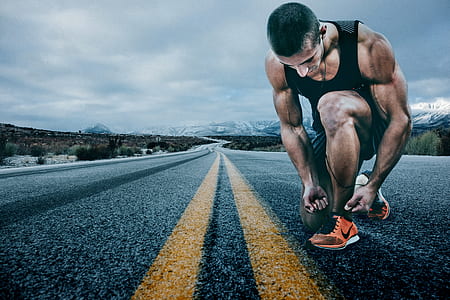 shallow focus photography of man in black tank top holding black shoe thumbnail