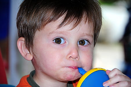 boy sipping on blue and yellow sippy cup thumbnail
