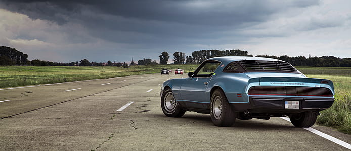 Blue Coupe on Brown Concrete Road thumbnail
