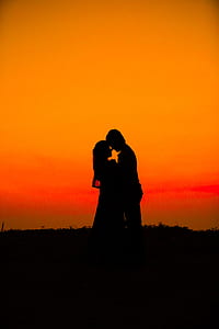 silhouette photography of woman and man standing of plants thumbnail