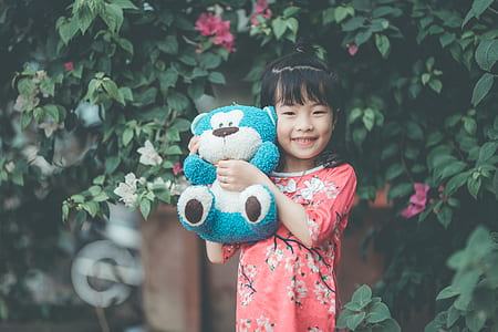 girl holding blue bear plush toy thumbnail