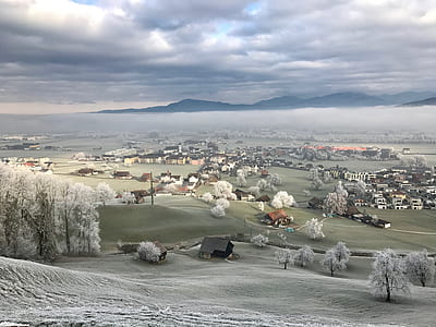 landmark photography of village under commulus clouds thumbnail