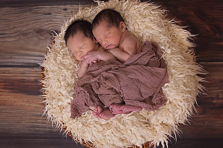two baby sleeping on white fur sleeping pad thumbnail