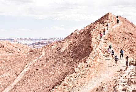 group of people walking on beige mountain during daytime thumbnail