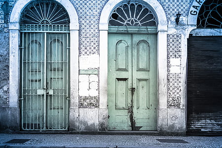 gray concrete house with green wooden doors at daytime thumbnail