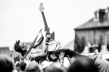 grayscale photography of man holding guitar thumbnail