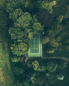 aerial view of tennis court between trees thumbnail
