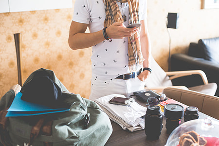 Man Checking His Phone while Packing for a Trip thumbnail