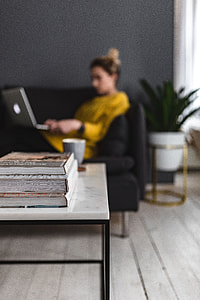 Young woman sitting on the sofa and working on her laptop thumbnail