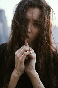 shallow focus photography of woman touching her lips with index finger thumbnail