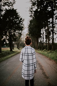 woman on road facing trees thumbnail