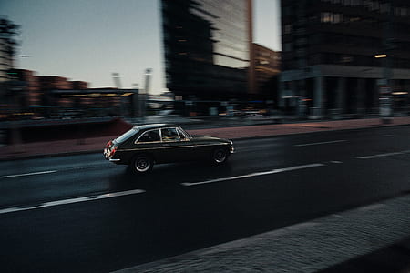 selective focus photography of black car running on road at daytime thumbnail