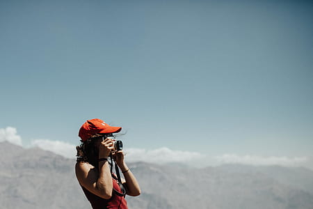woman wearing baseball cap holding camera thumbnail