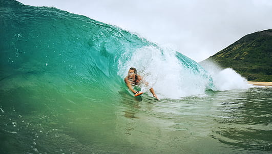 person on teal wave during daytime thumbnail