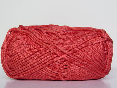 red yarn roll placed on white surface thumbnail
