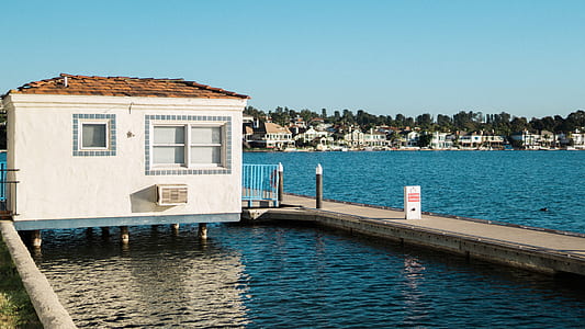white concrete house near brown wooden dock thumbnail