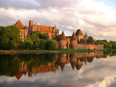 brown castle beside body of water at daytime thumbnail