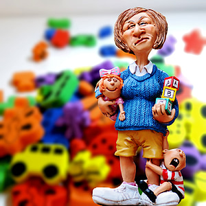 selective focus photography of woman holding baby figurine thumbnail