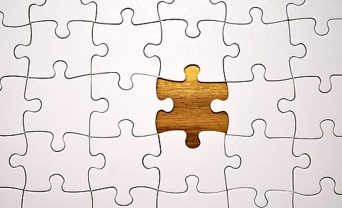 jigsaw puzzle with one piece missing on top of wooden surface thumbnail