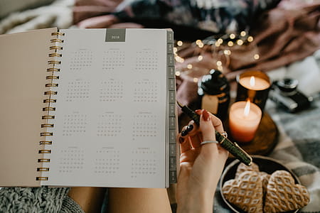 Writing in a notebook lying in bed, with coffee, candles, and gingerbreads thumbnail