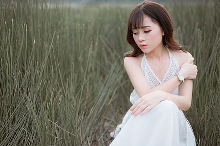 Woman Wearing White Halter Dress Surrounded By Grass thumbnail