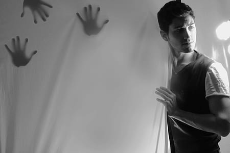 man wearing shirt holding white curtain thumbnail