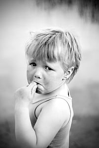 gray scale photography of toddler's thumb sucking thumbnail