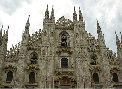 low angle photo of concrete cathedral under white cloudy skies thumbnail