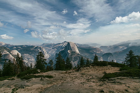 landscape photography of mountains and trees under cloudy skies thumbnail