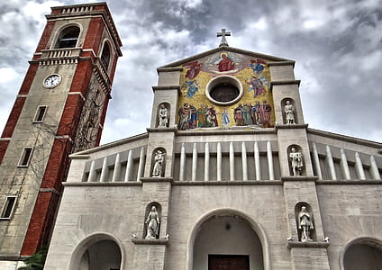 low angle photography of white, red, and gray concrete cathedral under cloudy sky thumbnail