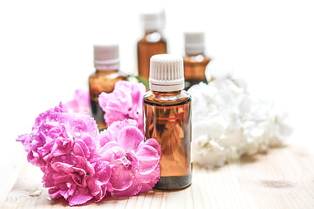 four brown bottles near on pink flowers thumbnail