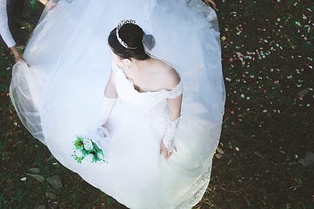 woman wearing white wedding dress sitting on the ground thumbnail