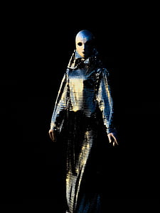 person wearing beige and blue mask and long-sleeved dress thumbnail