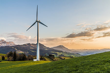 white windmill on green hills during daytime thumbnail