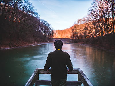 man standing on wooden dock in front of lake thumbnail